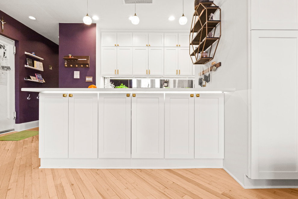 Imagen de cocina contemporánea con fregadero encastrado, puertas de armario blancas, salpicadero con efecto espejo y encimeras blancas