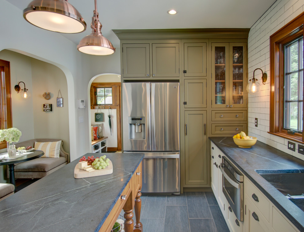 Example of a small eclectic u-shaped porcelain tile eat-in kitchen design in Columbus with an undermount sink, beaded inset cabinets, green cabinets, soapstone countertops, beige backsplash, subway tile backsplash, stainless steel appliances and an island