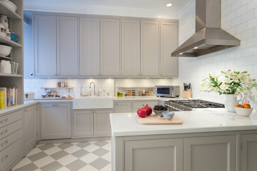Photo of a traditional grey and white u-shaped kitchen in Boston with a belfast sink, shaker cabinets, grey cabinets, white splashback, metro tiled splashback and a breakfast bar.