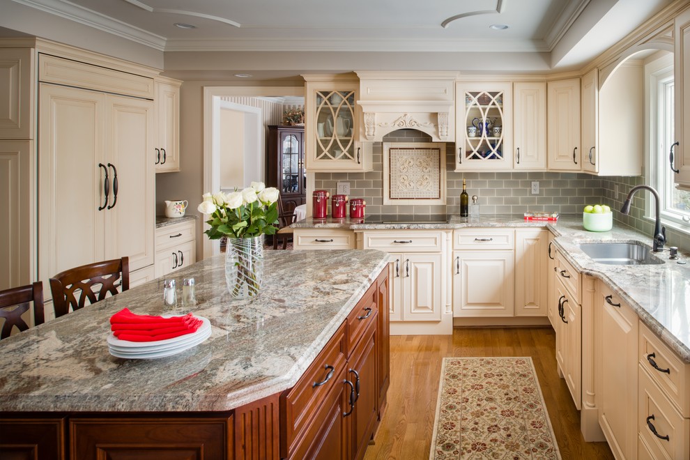 Exempel på ett klassiskt kök, med en undermonterad diskho, luckor med upphöjd panel, beige skåp, mellanmörkt trägolv och en köksö