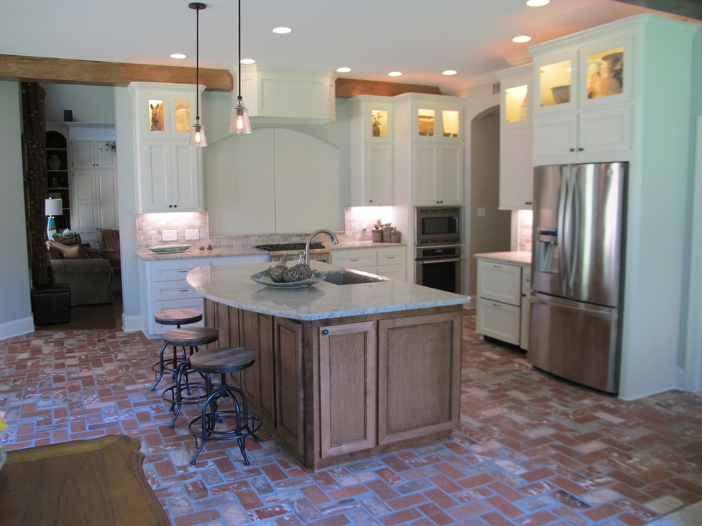 Inspiration for a large transitional galley brick floor open concept kitchen remodel in Other with an undermount sink, recessed-panel cabinets, white cabinets, solid surface countertops, white backsplash, ceramic backsplash, stainless steel appliances and an island