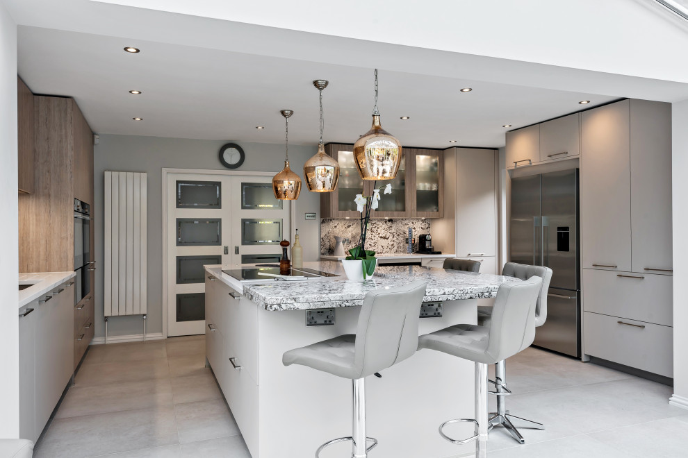 Contemporary kitchen in Berkshire with granite worktops, an island, flat-panel cabinets, grey cabinets, stainless steel appliances, grey floors and multicoloured worktops.
