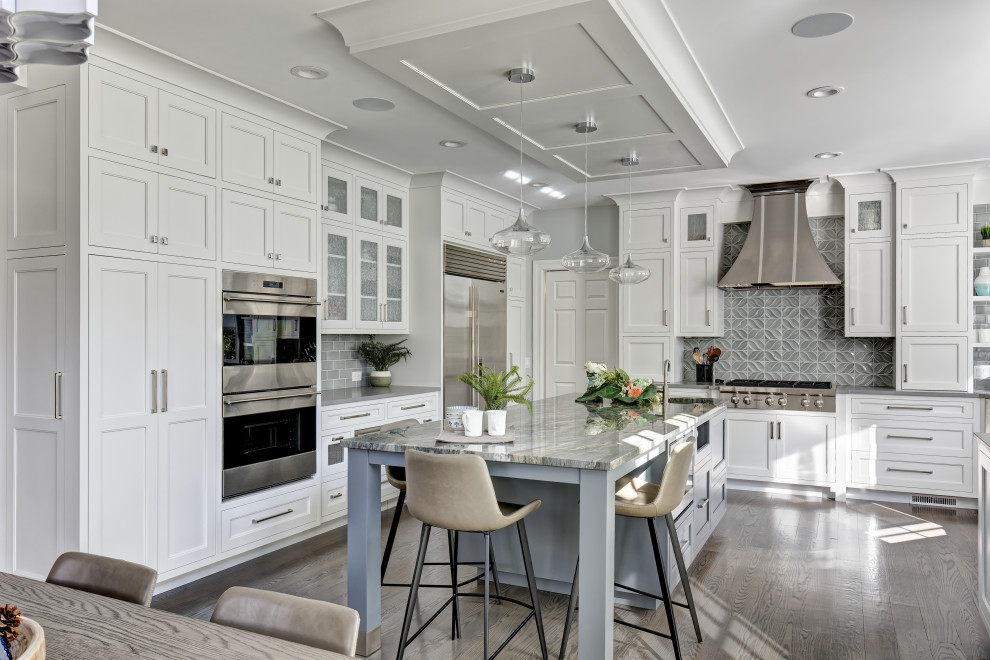 Inspiration for a large traditional u-shaped kitchen/diner in New York with a double-bowl sink, flat-panel cabinets, white cabinets, quartz worktops, green splashback, ceramic splashback, stainless steel appliances, porcelain flooring, an island, grey floors and grey worktops.