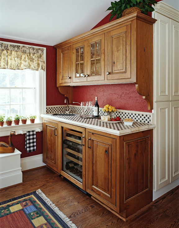 Landhaus Küche mit profilierten Schrankfronten, Arbeitsplatte aus Fliesen, Küchenrückwand in Rot und braunem Holzboden in Sonstige