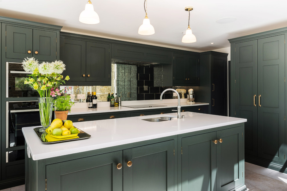 Inspiration for a large timeless l-shaped limestone floor and beige floor eat-in kitchen remodel in London with shaker cabinets, green cabinets, quartzite countertops, metallic backsplash, paneled appliances, an island, white countertops, an undermount sink and mirror backsplash