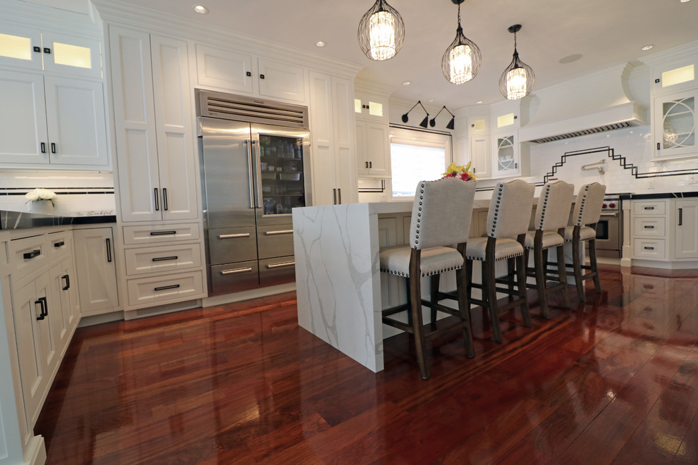 Example of a large transitional u-shaped dark wood floor and red floor eat-in kitchen design in Boston with a farmhouse sink, beaded inset cabinets, white cabinets, quartz countertops, white backsplash, porcelain backsplash, stainless steel appliances and an island