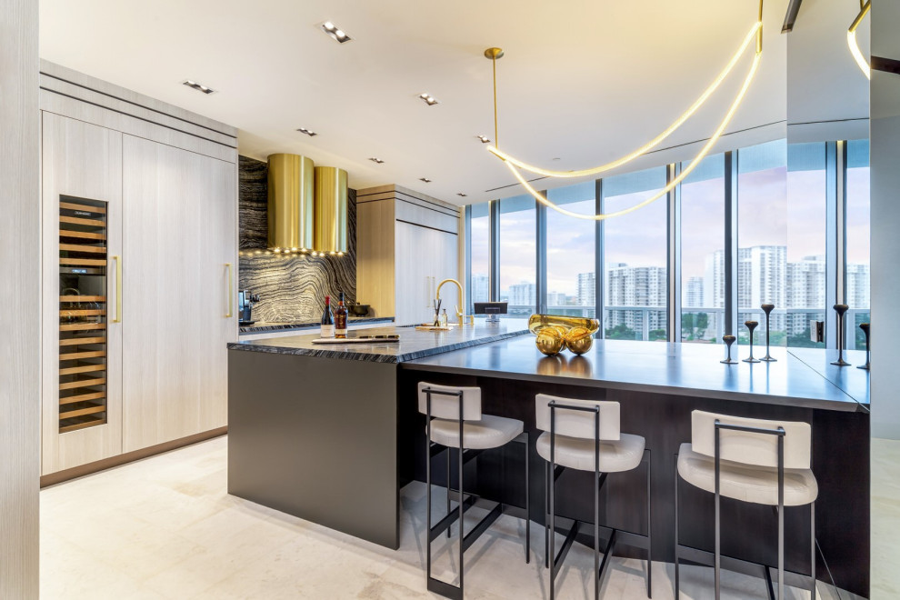 Example of a large trendy l-shaped porcelain tile and white floor eat-in kitchen design in Miami with an undermount sink, flat-panel cabinets, light wood cabinets, marble countertops, black backsplash, marble backsplash, paneled appliances, an island and black countertops