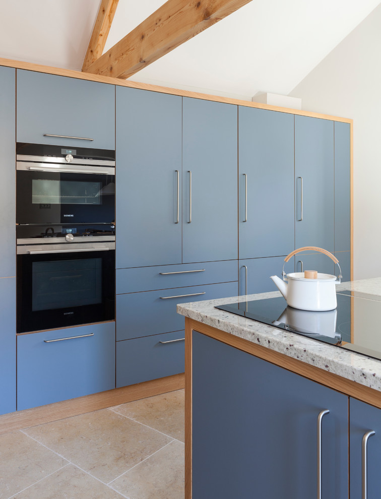 Medium sized contemporary l-shaped kitchen/diner in Wiltshire with a single-bowl sink, flat-panel cabinets, grey cabinets, granite worktops, integrated appliances, limestone flooring, an island and beige floors.
