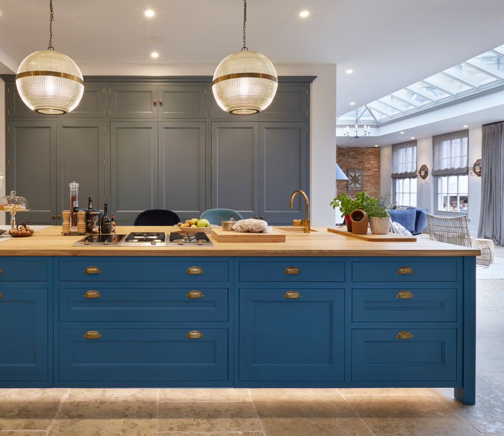 Große Klassische Küche mit Unterbauwaschbecken, Schrankfronten mit vertiefter Füllung, Arbeitsplatte aus Holz, Kücheninsel, braunem Boden, beiger Arbeitsplatte und blauen Schränken in Essex
