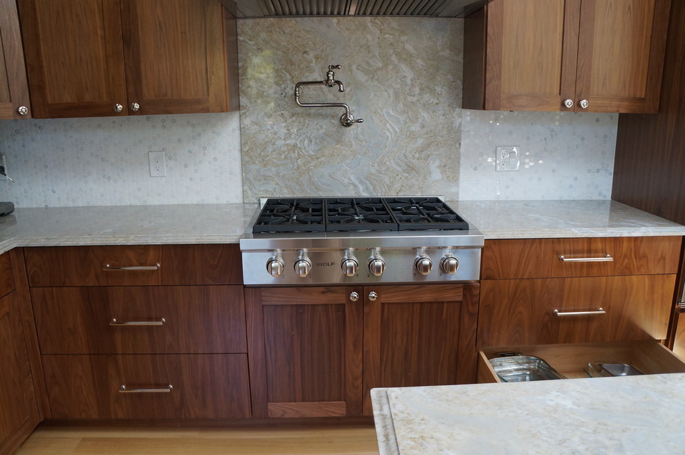 Esempio di una grande cucina moderna con ante lisce, ante marroni, top in superficie solida, paraspruzzi grigio, paraspruzzi con piastrelle a mosaico, elettrodomestici in acciaio inossidabile e parquet chiaro