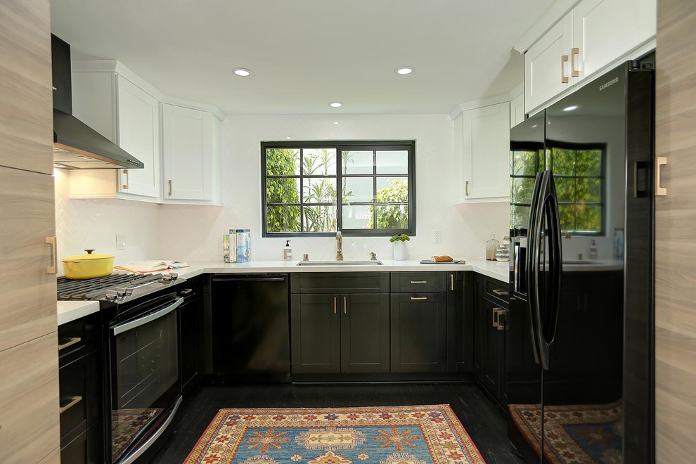 Modern inredning av ett mellanstort kök, med en enkel diskho, skåp i shakerstil, svarta skåp, bänkskiva i kvarts, vitt stänkskydd, stänkskydd i keramik, svarta vitvaror och målat trägolv