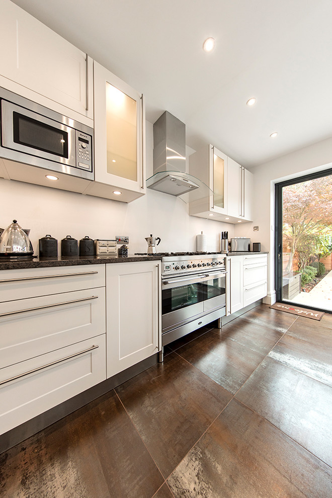 Medium sized contemporary l-shaped open plan kitchen in London with a submerged sink, shaker cabinets, white cabinets, granite worktops and an island.