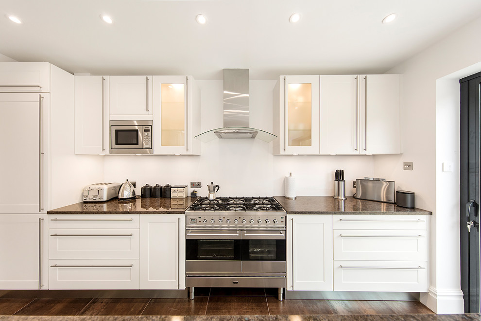Immagine di una cucina contemporanea di medie dimensioni con lavello sottopiano, ante in stile shaker, ante bianche e top in granito