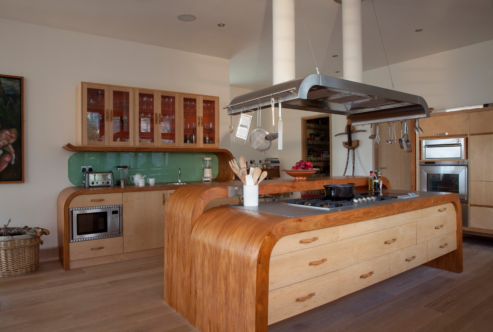Modelo de cocina comedor campestre grande con fregadero bajoencimera, salpicadero gris, suelo de madera clara y una isla