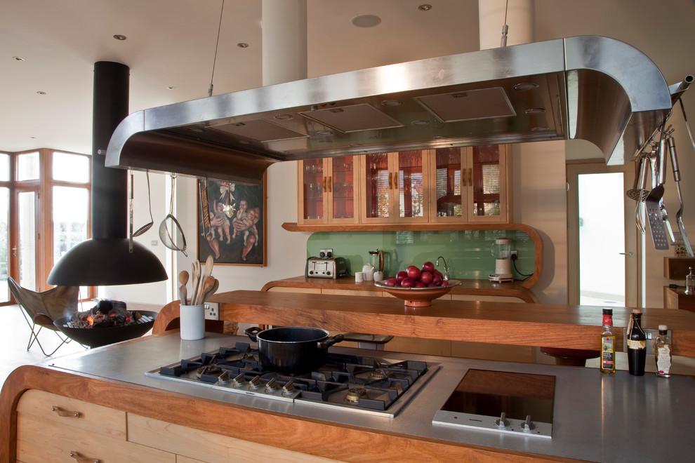Inredning av ett lantligt stort kök och matrum, med en undermonterad diskho, grönt stänkskydd, ljust trägolv och en köksö