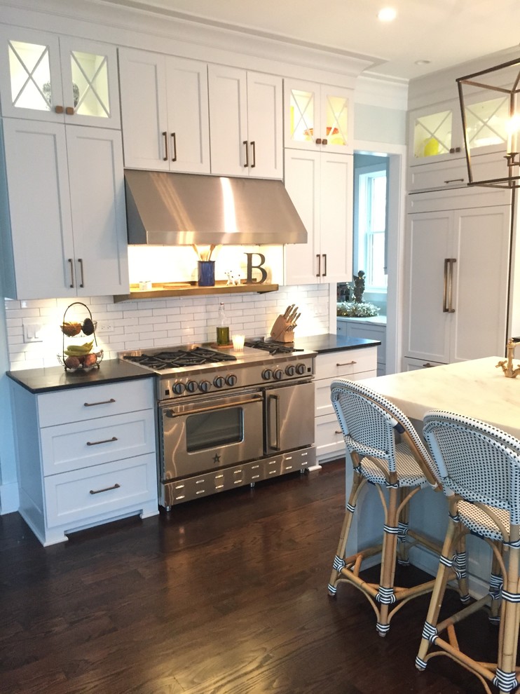 Example of a cottage kitchen design in Chicago with stainless steel appliances and an island