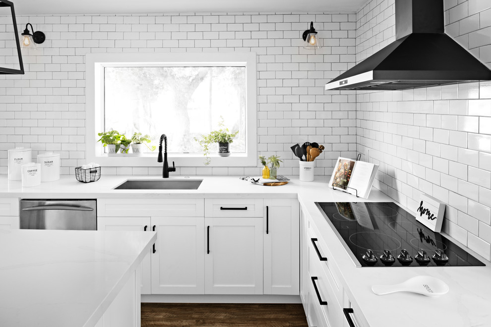 Inspiration för ett mellanstort lantligt vit vitt kök, med en undermonterad diskho, skåp i shakerstil, vita skåp, bänkskiva i kvartsit, vitt stänkskydd, stänkskydd i tunnelbanekakel, svarta vitvaror, vinylgolv, en köksö och brunt golv