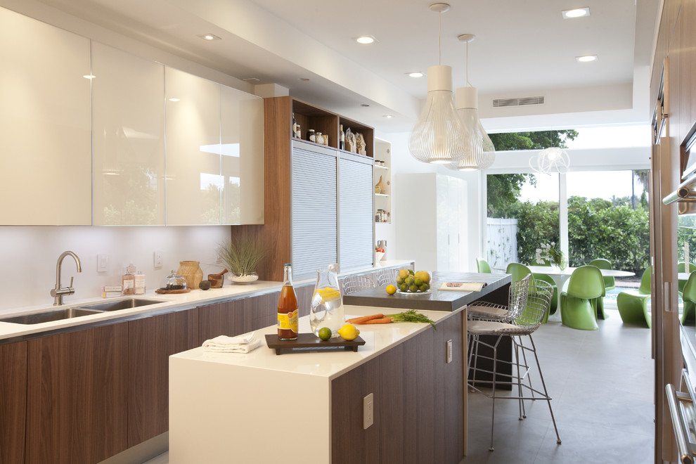 На фото: кухня в стиле модернизм с обеденным столом, плоскими фасадами, белыми фасадами и двухцветным гарнитуром с