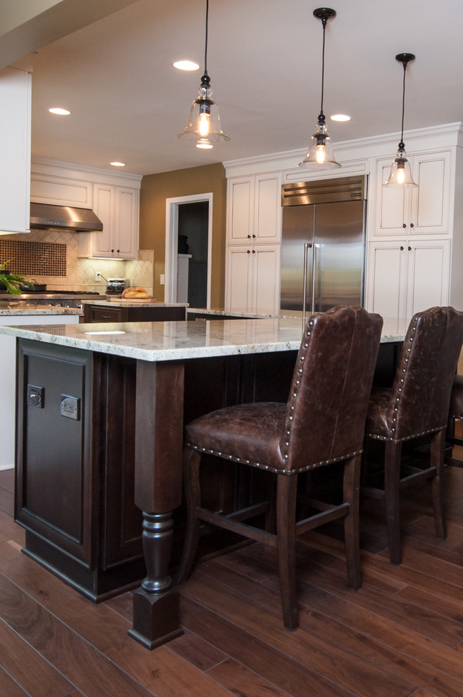 Eat-in kitchen - large traditional l-shaped dark wood floor eat-in kitchen idea in Detroit with an undermount sink, recessed-panel cabinets, white cabinets, granite countertops, brown backsplash, stone tile backsplash, stainless steel appliances and two islands