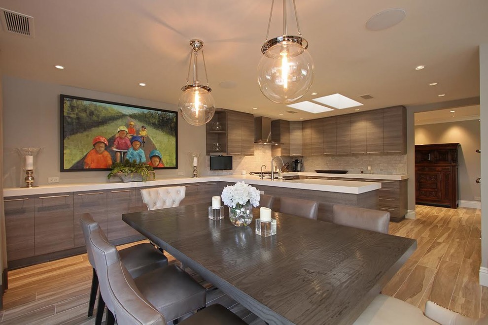 Mid-sized minimalist u-shaped eat-in kitchen photo in Los Angeles with a double-bowl sink, flat-panel cabinets, medium tone wood cabinets, gray backsplash, paneled appliances and a peninsula