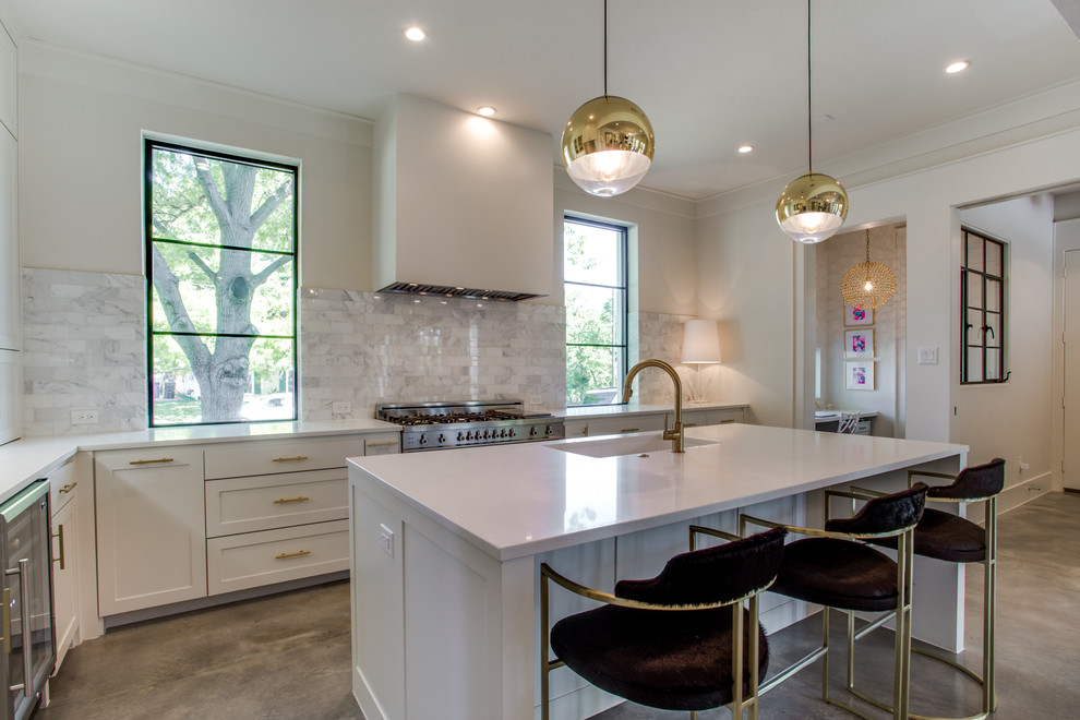 Example of a transitional l-shaped kitchen design in Dallas with an undermount sink, shaker cabinets, white cabinets, gray backsplash, porcelain backsplash, stainless steel appliances and an island