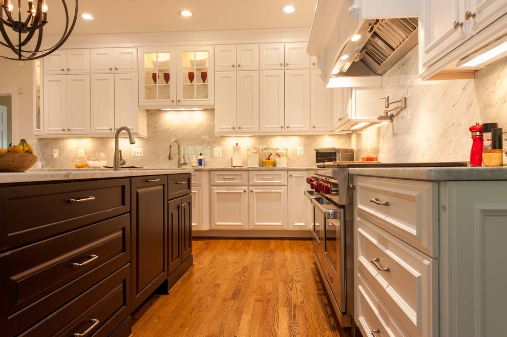 Large elegant l-shaped dark wood floor and brown floor open concept kitchen photo in DC Metro with an undermount sink, recessed-panel cabinets, white cabinets, marble countertops, gray backsplash, stone slab backsplash, stainless steel appliances and an island