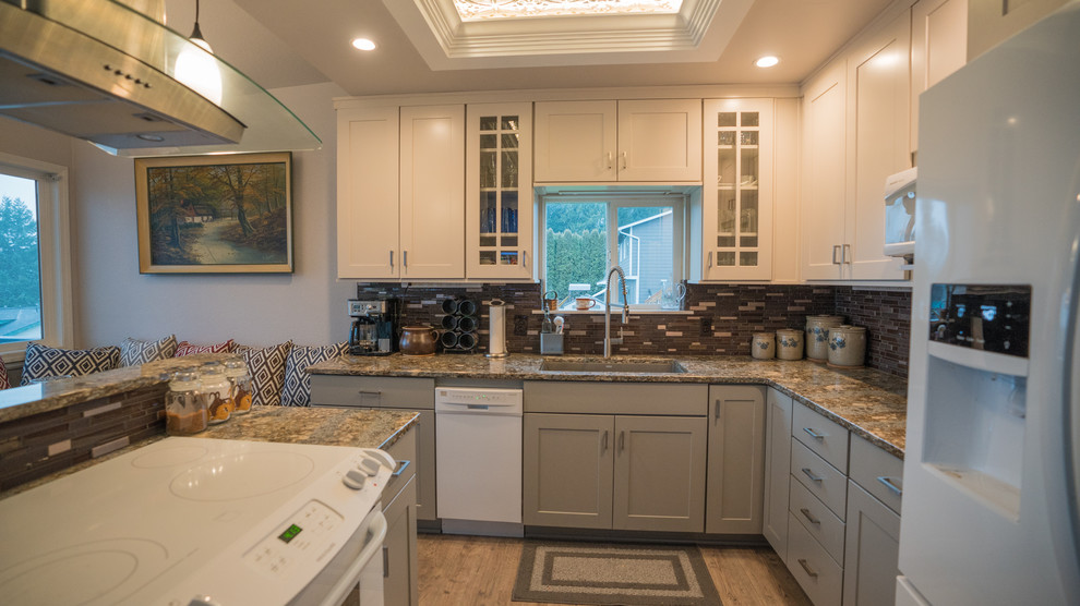 Exempel på ett mellanstort klassiskt kök, med en undermonterad diskho, luckor med infälld panel, vita skåp, bänkskiva i kvarts, flerfärgad stänkskydd, stänkskydd i glaskakel, vita vitvaror, vinylgolv, en köksö och brunt golv