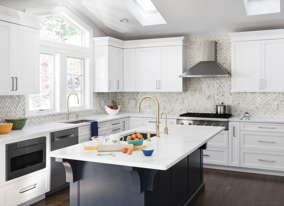 Mid-sized trendy u-shaped medium tone wood floor and brown floor enclosed kitchen photo in New York with a drop-in sink, shaker cabinets, white cabinets, quartzite countertops, gray backsplash, marble backsplash, stainless steel appliances, an island and white countertops