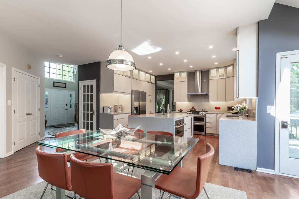 Moderne Küche mit weißen Schränken, Granit-Arbeitsplatte, Küchengeräten aus Edelstahl, hellem Holzboden, Kücheninsel und braunem Boden in Washington, D.C.