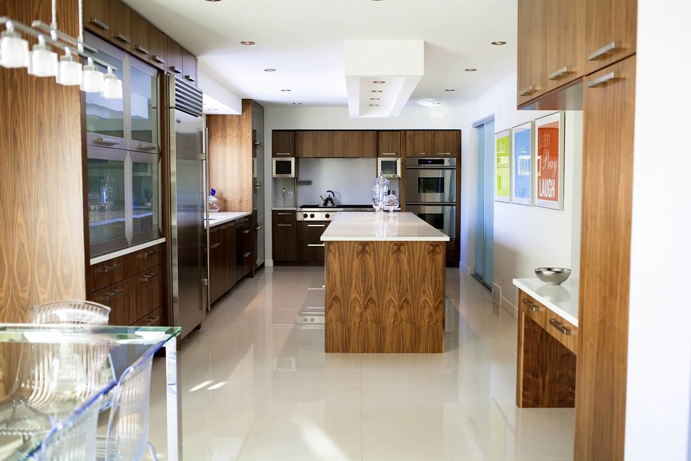 Bild på ett mellanstort funkis kök, med en undermonterad diskho, släta luckor, skåp i mellenmörkt trä, bänkskiva i kvarts, vitt stänkskydd, stänkskydd i sten, rostfria vitvaror, klinkergolv i porslin, en köksö och vitt golv