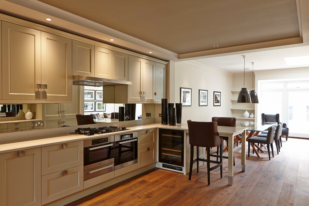 Idéer för mellanstora funkis kök och matrum, med luckor med infälld panel, vita skåp, marmorbänkskiva, rostfria vitvaror och mellanmörkt trägolv