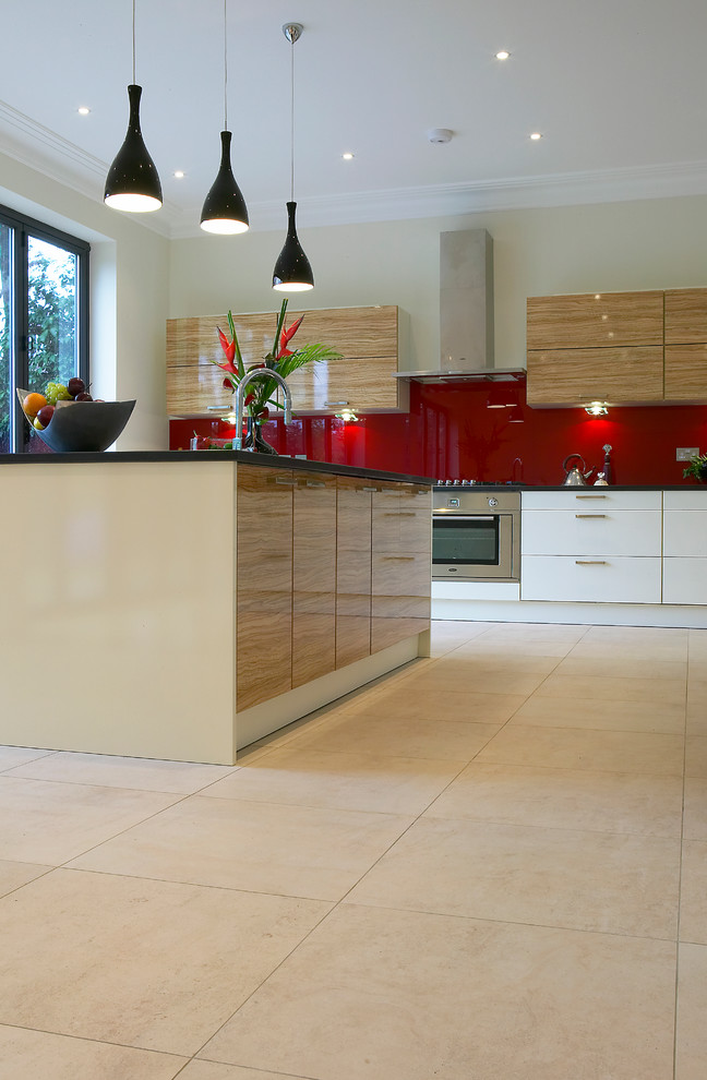 Inspiration for a large contemporary open plan kitchen in Berkshire with flat-panel cabinets, white cabinets, granite worktops, red splashback, glass sheet splashback, stainless steel appliances, porcelain flooring and an island.