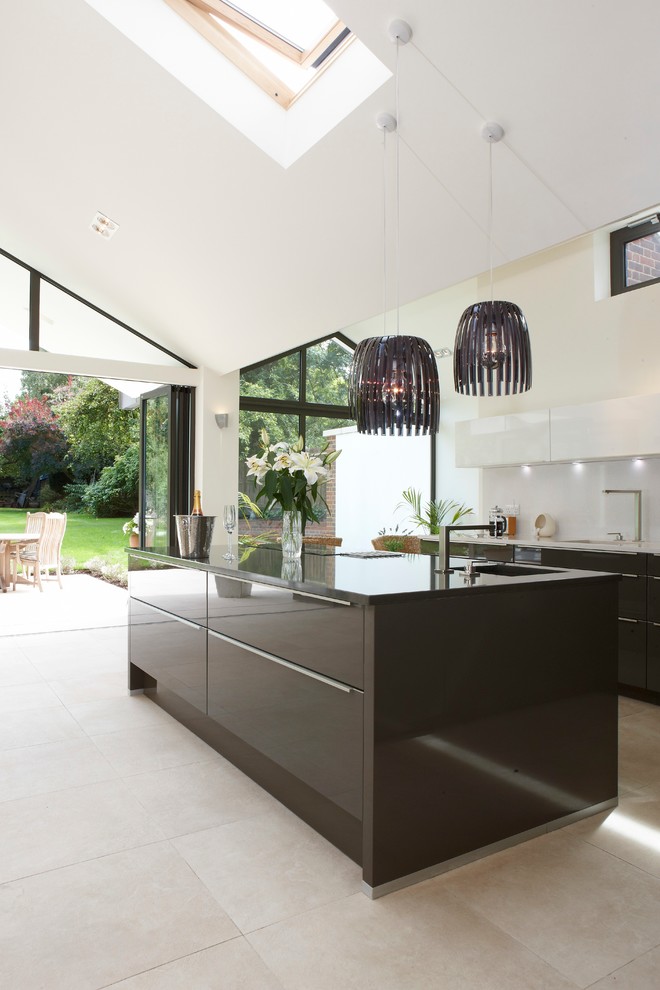 Inspiration for an expansive contemporary kitchen/diner in Berkshire with limestone flooring, an island, a submerged sink, flat-panel cabinets and white splashback.