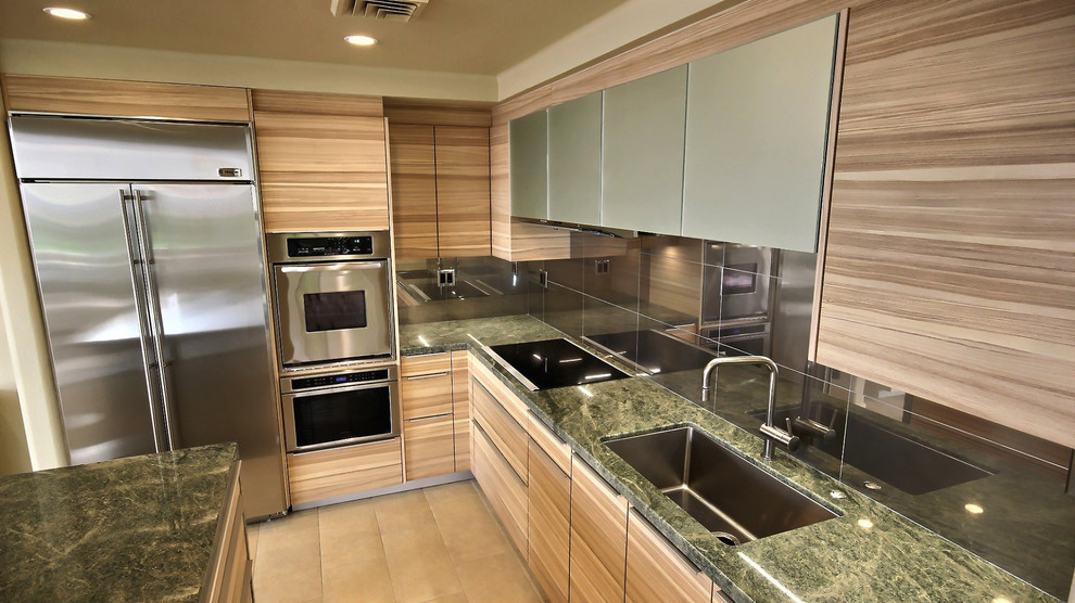 Bild på ett mellanstort funkis kök, med en undermonterad diskho, släta luckor, skåp i mellenmörkt trä, granitbänkskiva, stänkskydd i porslinskakel, rostfria vitvaror, klinkergolv i porslin och en halv köksö