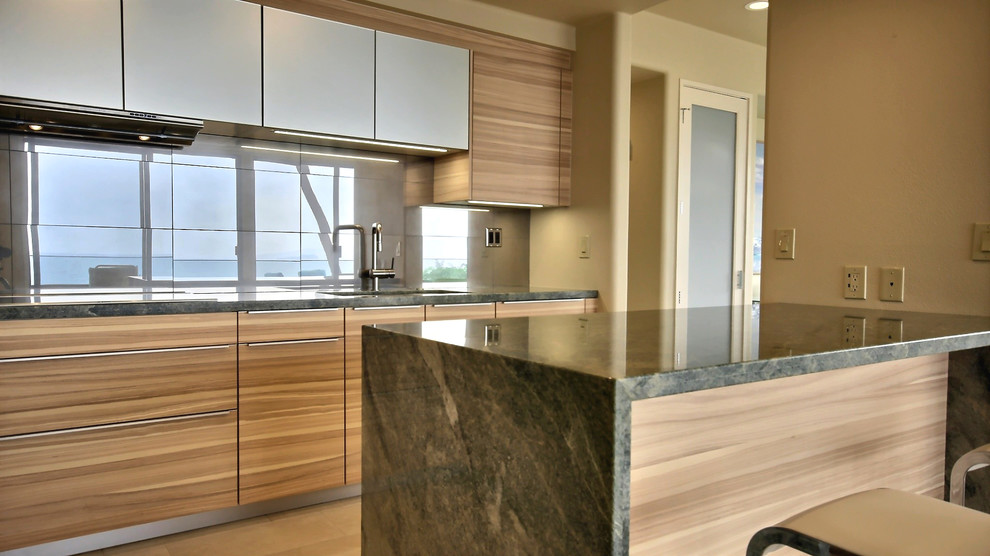 Example of a trendy eat-in kitchen design in Hawaii with an undermount sink, flat-panel cabinets, medium tone wood cabinets, granite countertops, porcelain backsplash and stainless steel appliances
