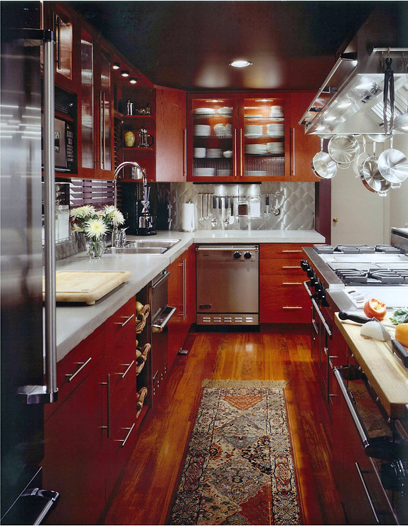 Bild på ett litet eklektiskt kök, med en dubbel diskho, släta luckor, röda skåp, bänkskiva i betong, stänkskydd med metallisk yta, rostfria vitvaror, mellanmörkt trägolv och en köksö