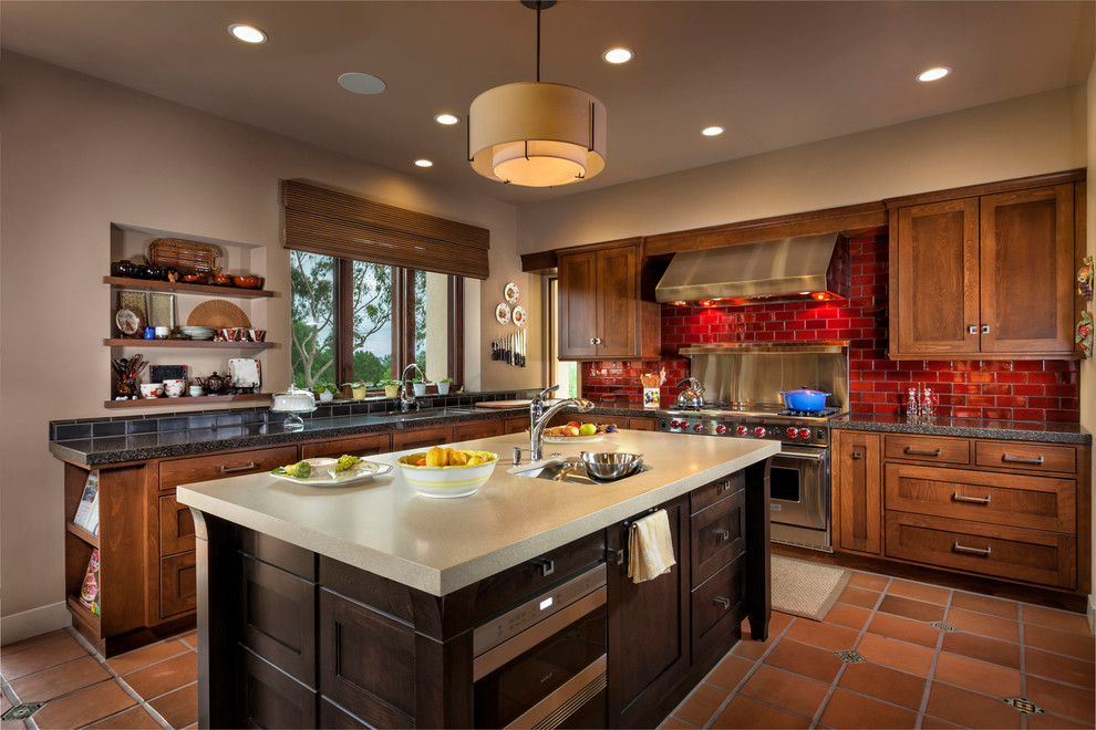 Traditional l-shaped kitchen in Orange County with a submerged sink, shaker cabinets, dark wood cabinets, red splashback, metro tiled splashback and stainless steel appliances.