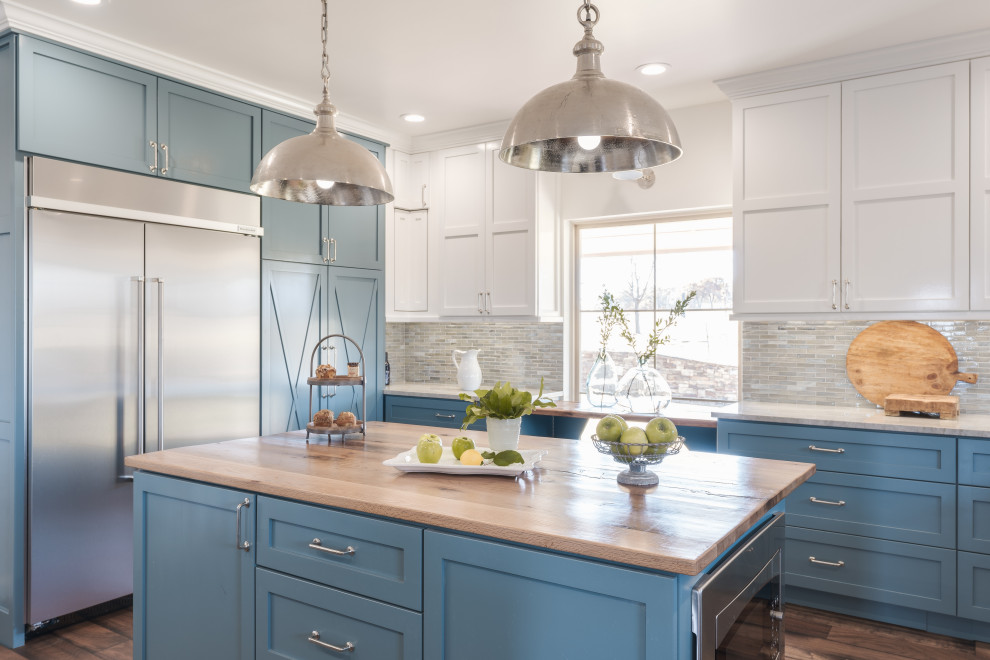 Inspiration for a large transitional u-shaped medium tone wood floor kitchen remodel in Oklahoma City with a farmhouse sink, shaker cabinets, blue cabinets, quartzite countertops, multicolored backsplash, glass tile backsplash, stainless steel appliances, two islands and white countertops