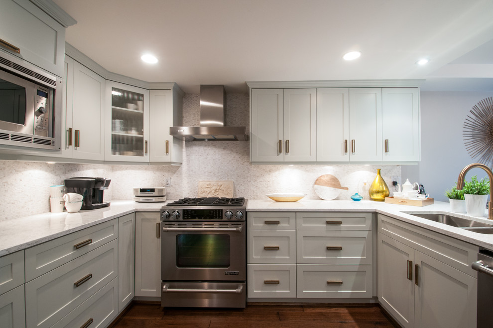 Photo of a medium sized classic u-shaped kitchen in Vancouver with raised-panel cabinets, stainless steel appliances, dark hardwood flooring, a breakfast bar, a double-bowl sink and multi-coloured splashback.