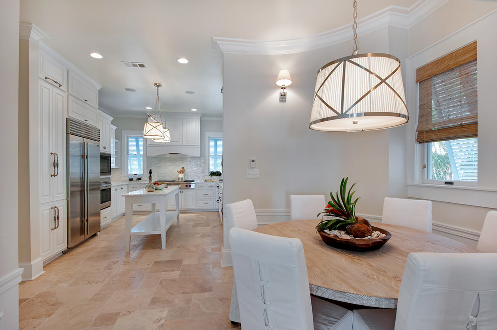 Eat-in kitchen - large tropical u-shaped limestone floor eat-in kitchen idea in Miami with beaded inset cabinets, white cabinets, marble countertops, white backsplash, stone tile backsplash, stainless steel appliances and an island