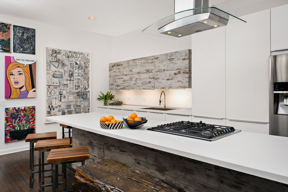 Esempio di un cucina con isola centrale design con ante bianche, paraspruzzi giallo, elettrodomestici in acciaio inossidabile e pavimento marrone