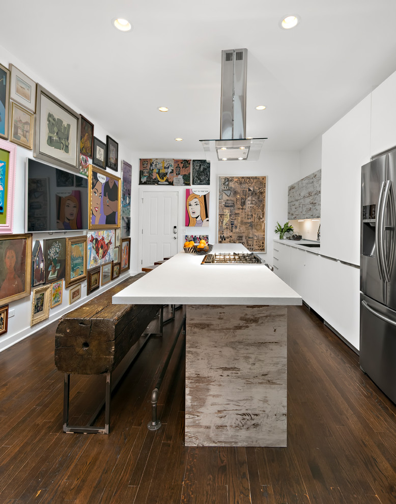 シカゴにあるエクレクティックスタイルのおしゃれなアイランドキッチン (白いキャビネット、黄色いキッチンパネル、シルバーの調理設備、茶色い床) の写真