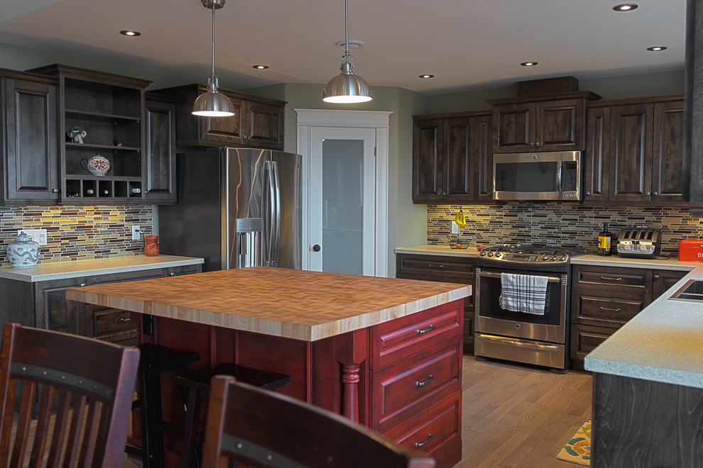 Example of a large arts and crafts u-shaped medium tone wood floor and gray floor eat-in kitchen design in Other with a drop-in sink, raised-panel cabinets, red cabinets, wood countertops, brown backsplash, glass tile backsplash, stainless steel appliances and an island