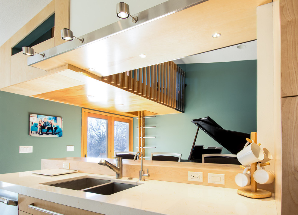 Imagen de cocina comedor contemporánea grande con armarios con paneles lisos, puertas de armario de madera clara, electrodomésticos de acero inoxidable y una isla
