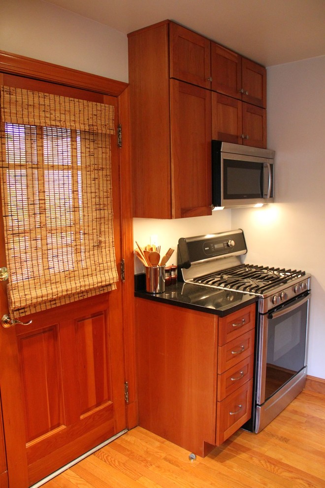 This is an example of a small classic l-shaped enclosed kitchen in DC Metro with a submerged sink, shaker cabinets, medium wood cabinets, granite worktops, stainless steel appliances, medium hardwood flooring and no island.