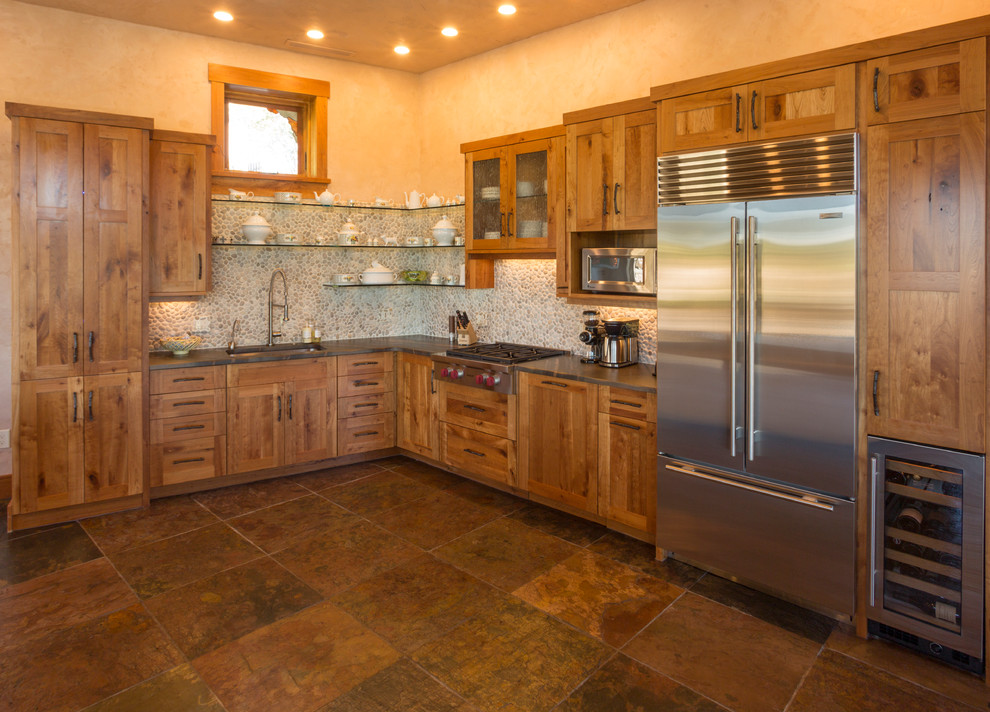 Large mountain style l-shaped ceramic tile kitchen photo in Denver with an undermount sink, medium tone wood cabinets, stainless steel appliances, no island, shaker cabinets and stone tile backsplash