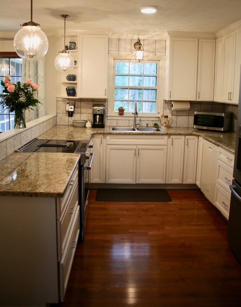 Photo of a small traditional u-shaped kitchen/diner in Atlanta with a double-bowl sink, flat-panel cabinets, white cabinets, granite worktops, white splashback, porcelain splashback, stainless steel appliances, medium hardwood flooring, a breakfast bar, brown floors and beige worktops.