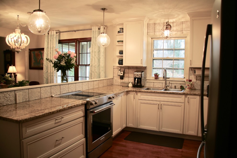 Idéer för ett litet klassiskt beige kök, med en dubbel diskho, släta luckor, vita skåp, granitbänkskiva, vitt stänkskydd, stänkskydd i porslinskakel, rostfria vitvaror, mellanmörkt trägolv, en halv köksö och brunt golv