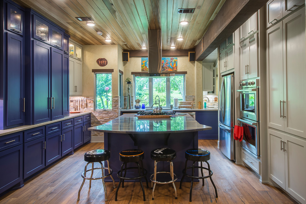 Foto di una cucina chic con ante in stile shaker, ante blu, paraspruzzi bianco, elettrodomestici in acciaio inossidabile, pavimento in legno massello medio e pavimento marrone