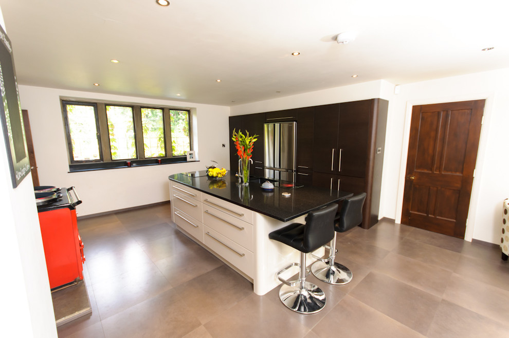 Large contemporary single-wall open plan kitchen in Other with an integrated sink, flat-panel cabinets, white cabinets, wood worktops, stainless steel appliances and an island.